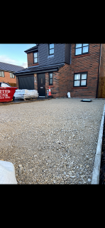 Here we can see the completed MOT type 3 which has now been compacted. The image shows the newly levelled drainage cover and resin mixtures ready in the background. natural paving manchester