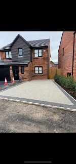 The finished article from the kerb side. The image shows road cones that have been left in place to prevent pedestrians from waling on the wet driveway. Low maintenance garden at its best.